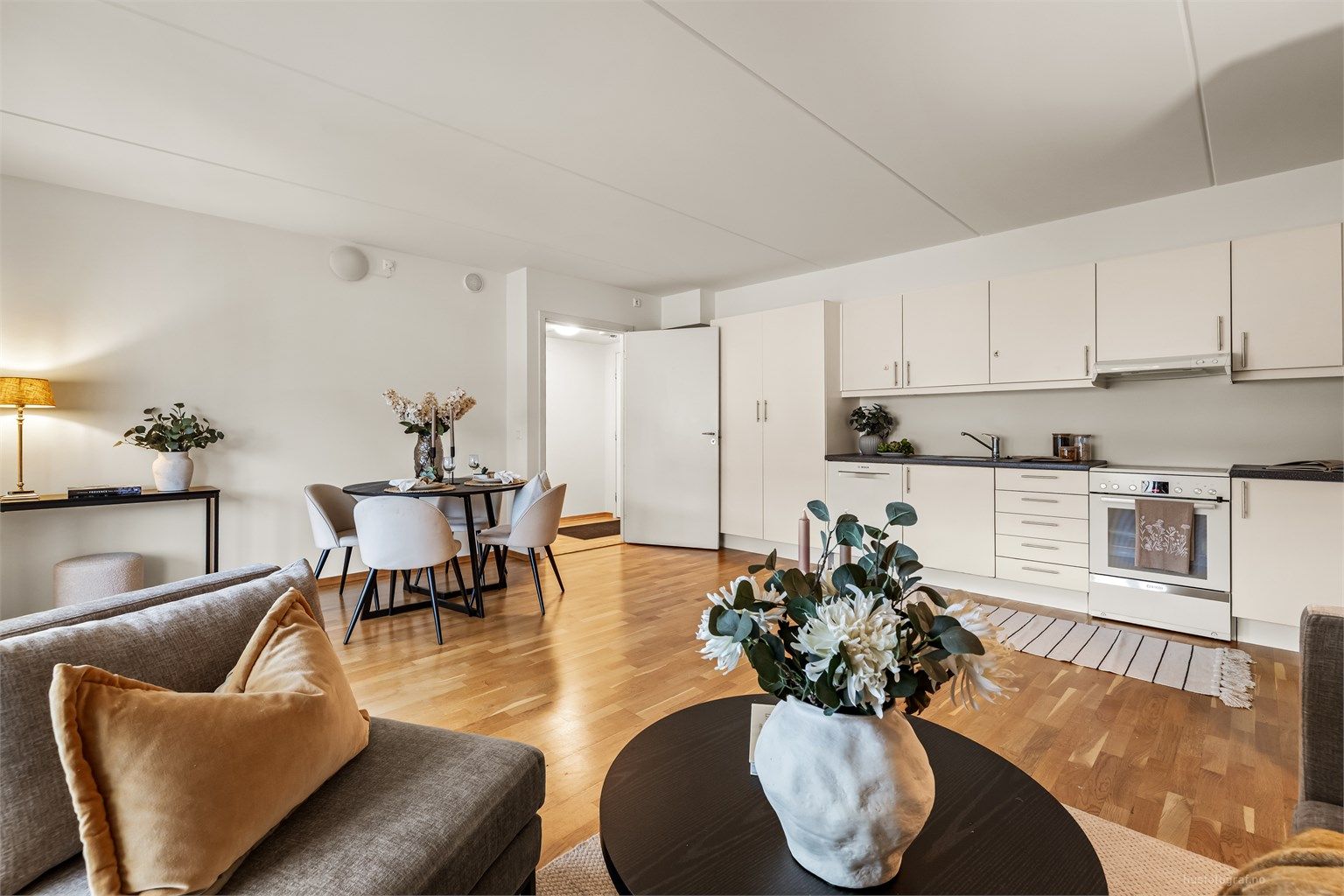 Åpen kjøkken- og stueløsning med sofaområde samt spiseplass.