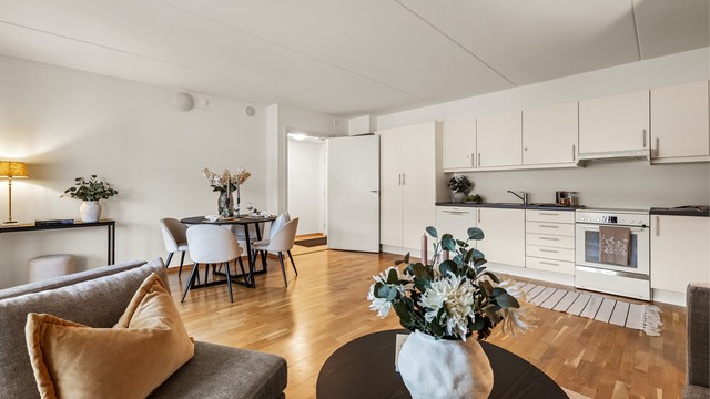 Åpen kjøkken- og stueløsning med sofaområde samt spiseplass.