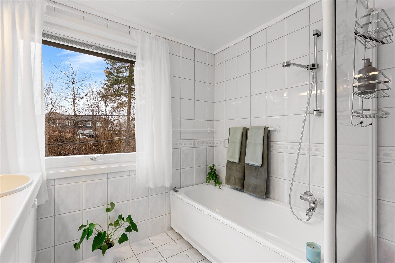 Rommet er utstyrt med både badekar og et separat dusjhjørne med skyvedør.