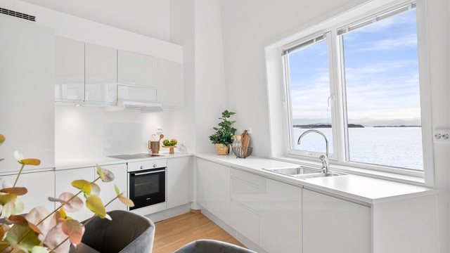 Kjøkkenet er i moderne og fint design fra HTH med lyse fronter og lys benkeplate. Ved kjøkkenet er det god plass til spisebord og det er flott sjøutsikt.