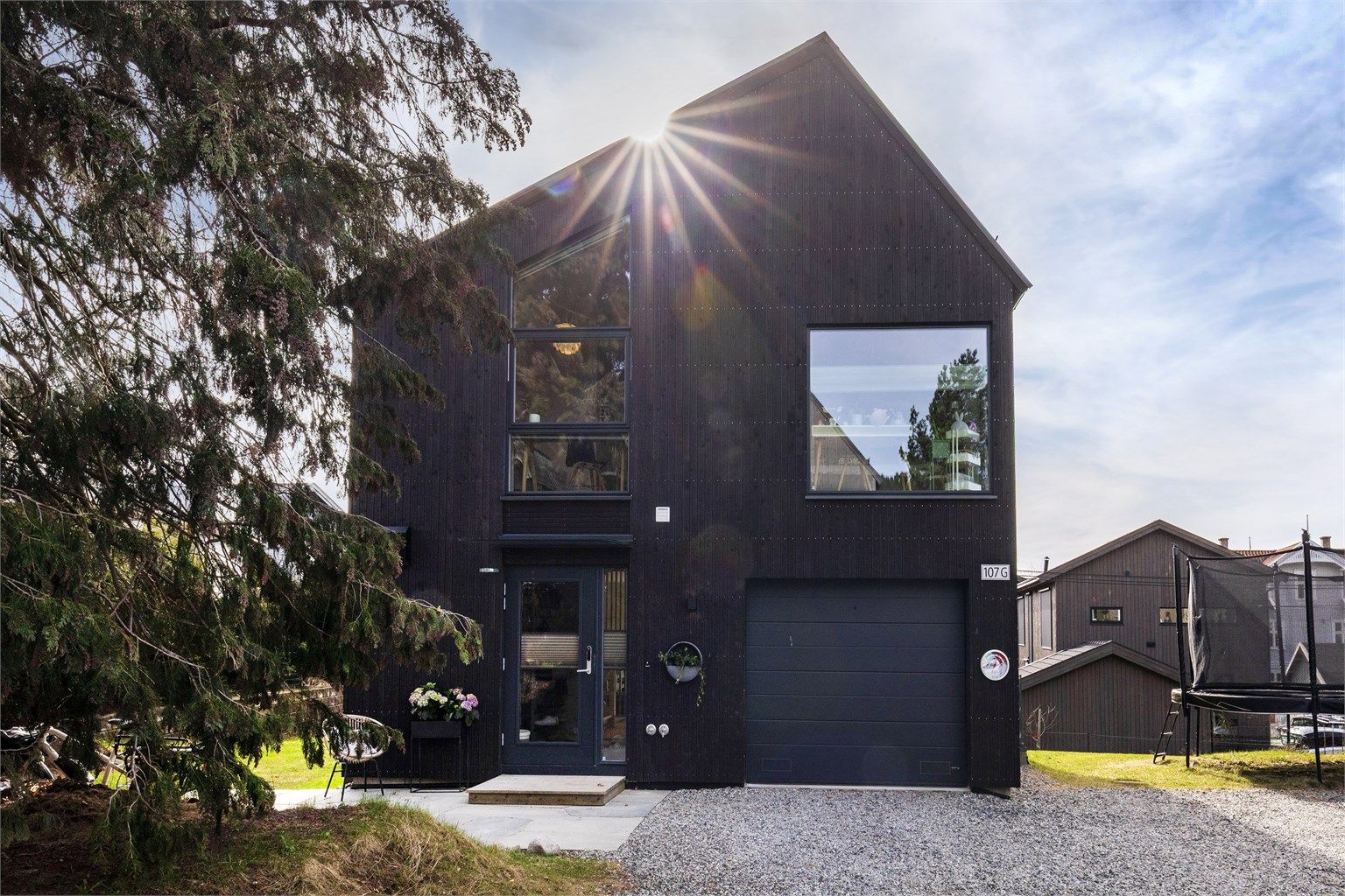 Garasje for én bil med elbillader. I tillegg kan du parkere på oppstillingsplass til høyre for huset foran trampolinen