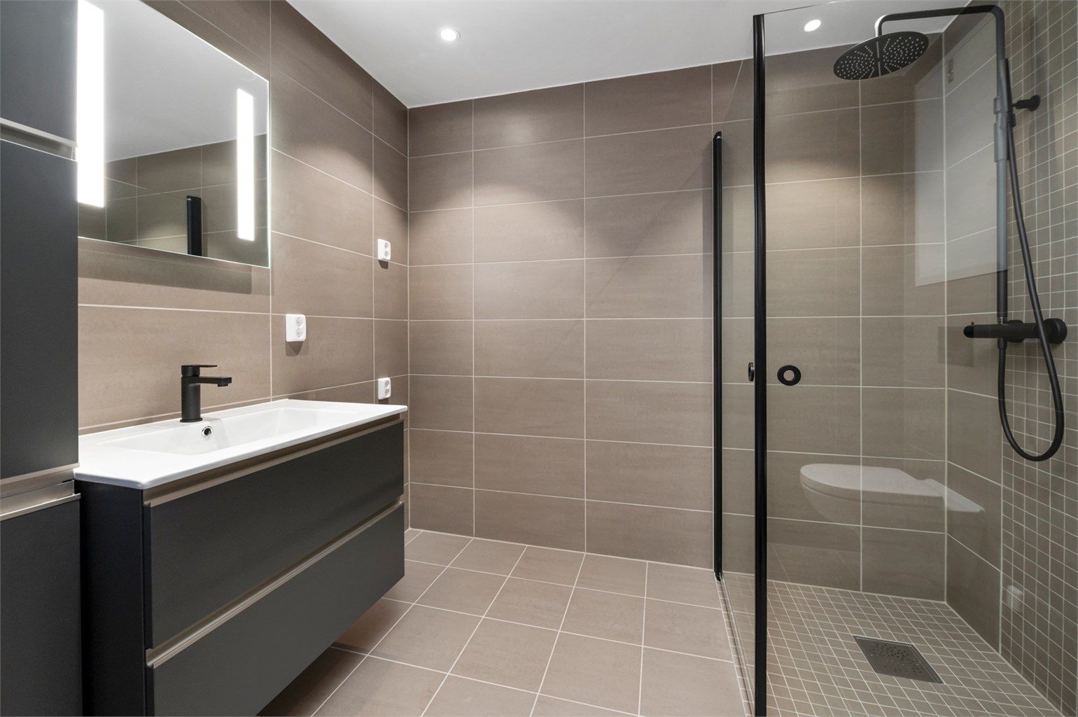 Badet måler 5 kvm og er pent flislagt med varme i gulv, opplegg for vaskemaskin og downlights i himling.