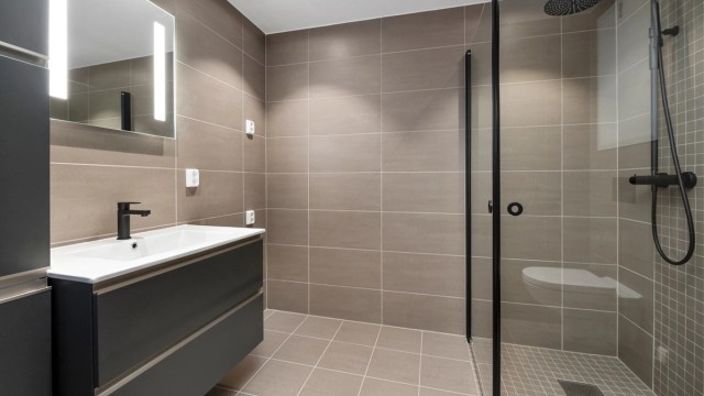 Badet måler 5 kvm og er pent flislagt med varme i gulv, opplegg for vaskemaskin og downlights i himling.