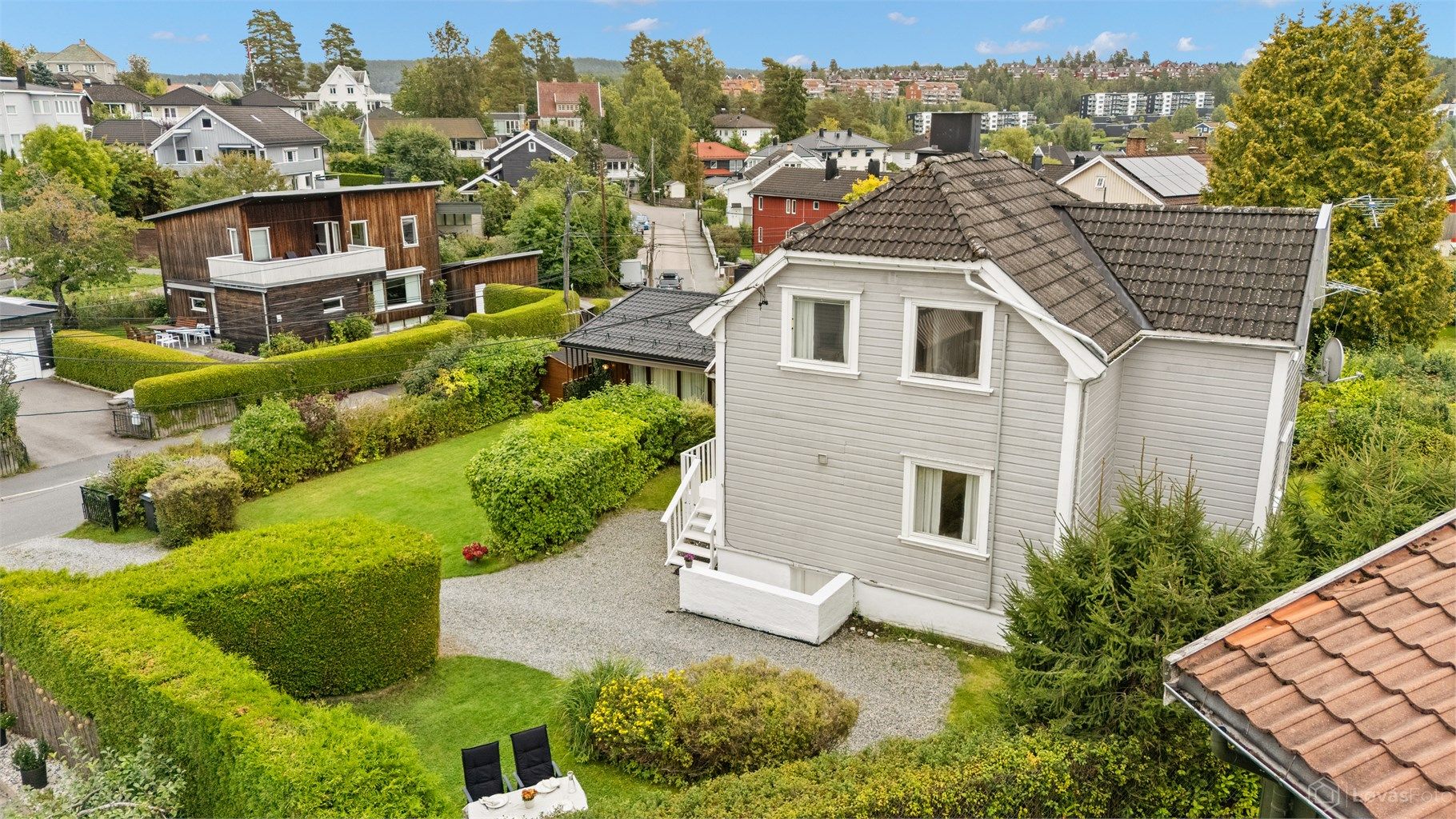 Boligen er omkranset av grønne hekker og et hyggelig nabolag.