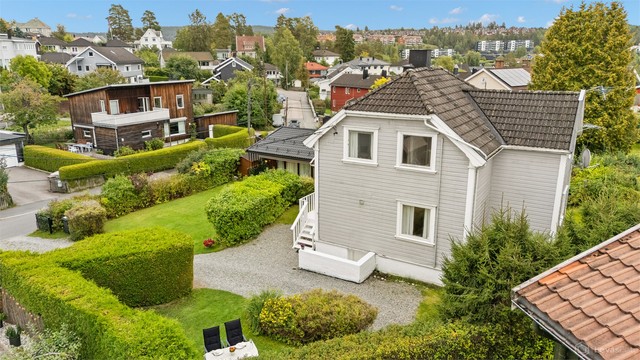 Boligen er omkranset av grønne hekker og et hyggelig nabolag.