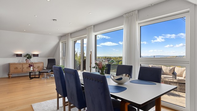 Spisestuen har plass til langbord for store selskaper og utsikt mot åsene.