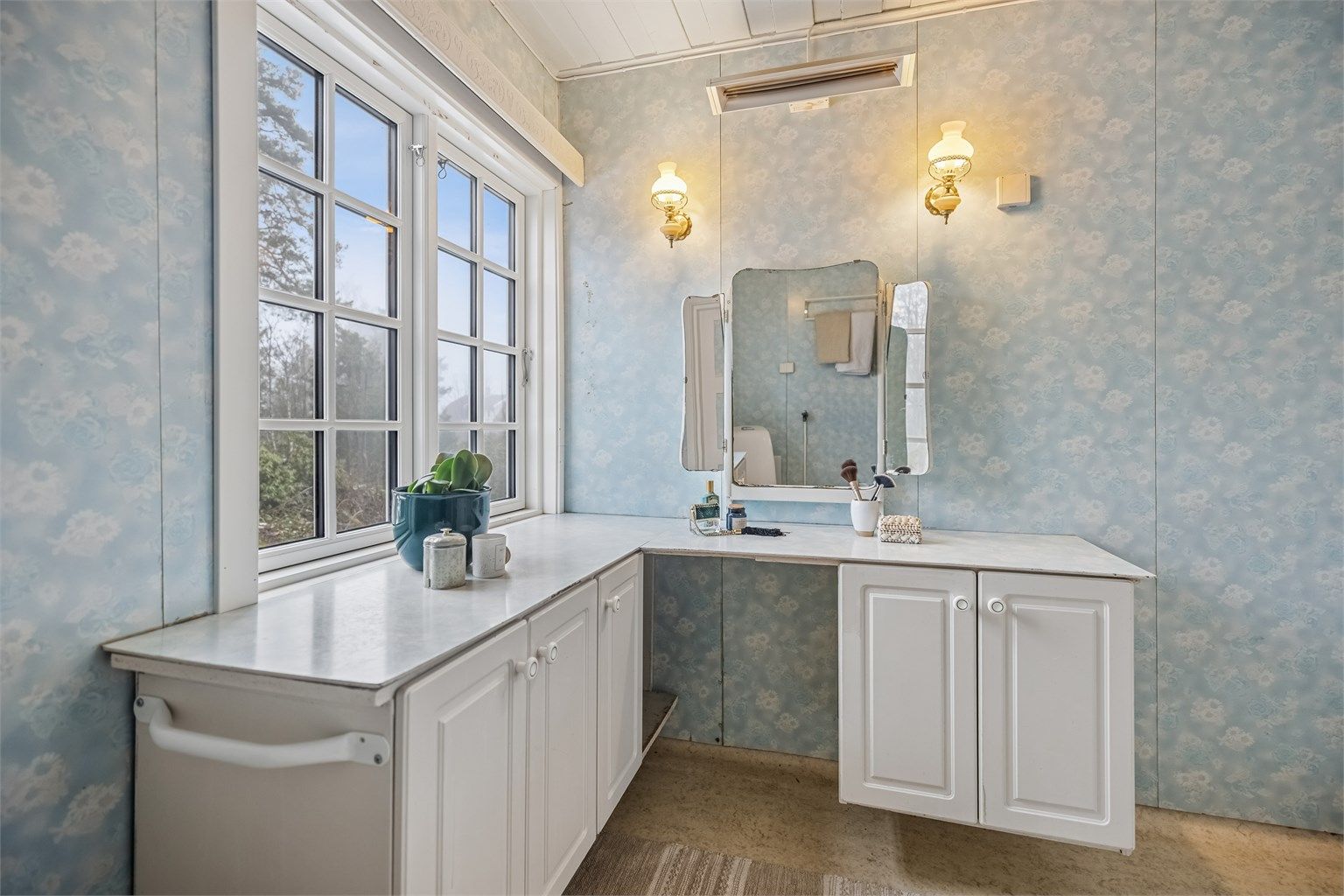 Eldre bad med dusjkabinett, servantinnredning, gulvstående toalett og opplegg for vaskemaskin.