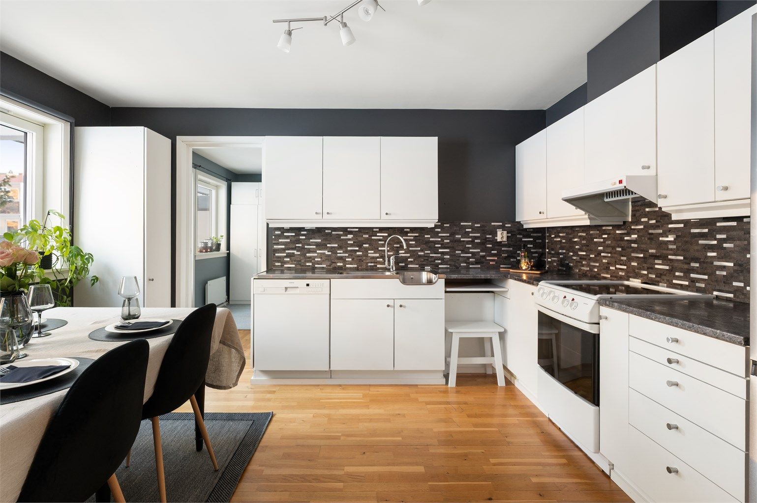 Kjøkkeninnredningen har glatte fronter, laminat benkeplate og kullfilterventilator.