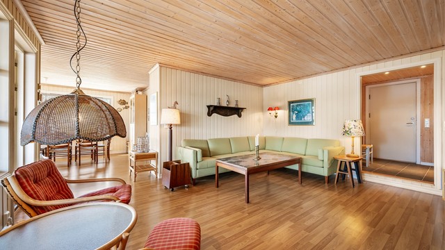 Den romslige stuen henger naturlig sammen med spisestuen og gir god plass for både avslapning og sosiale sammenkomster.