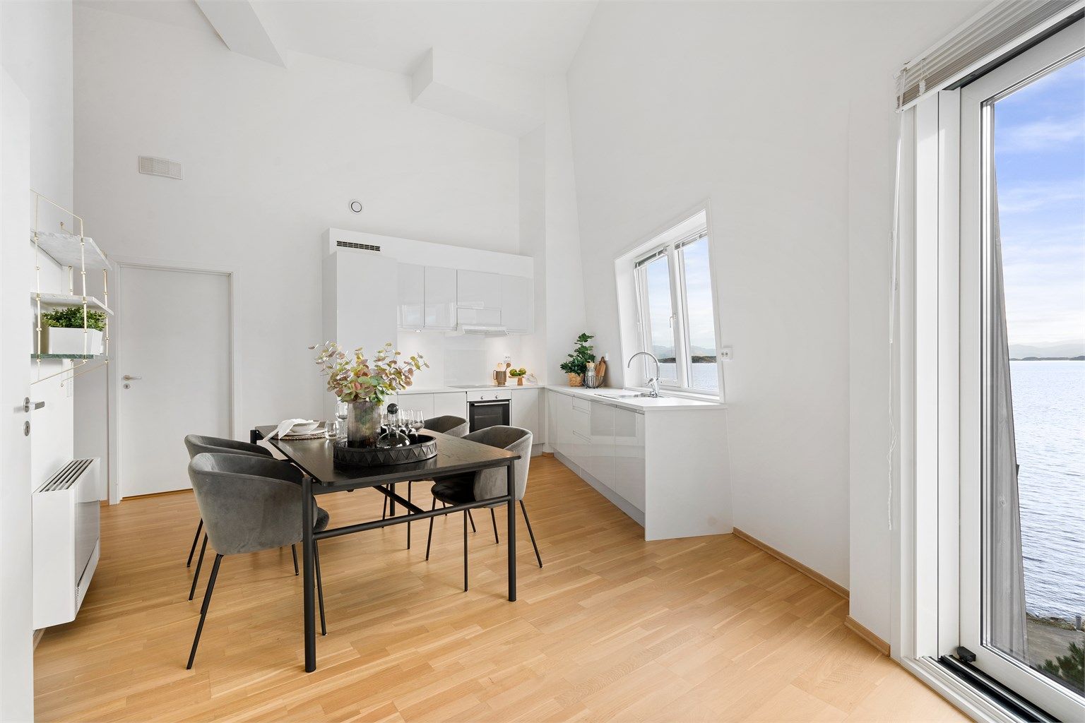 
Kjøkkenet er i moderne og fint design med lyse fronter og lys benkeplate.  Ved kjøkkenet er det god plass til spisebord og det er flott sjøutsikt. 