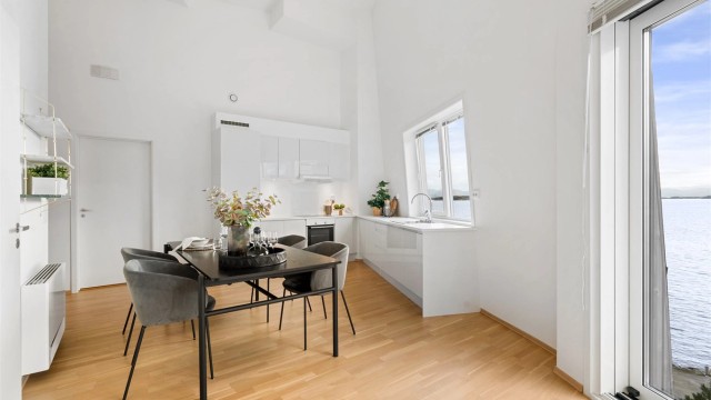 Kjøkkenet er i moderne og fint design med lyse fronter og lys benkeplate. Ved kjøkkenet er det god plass til spisebord og det er flott sjøutsikt.