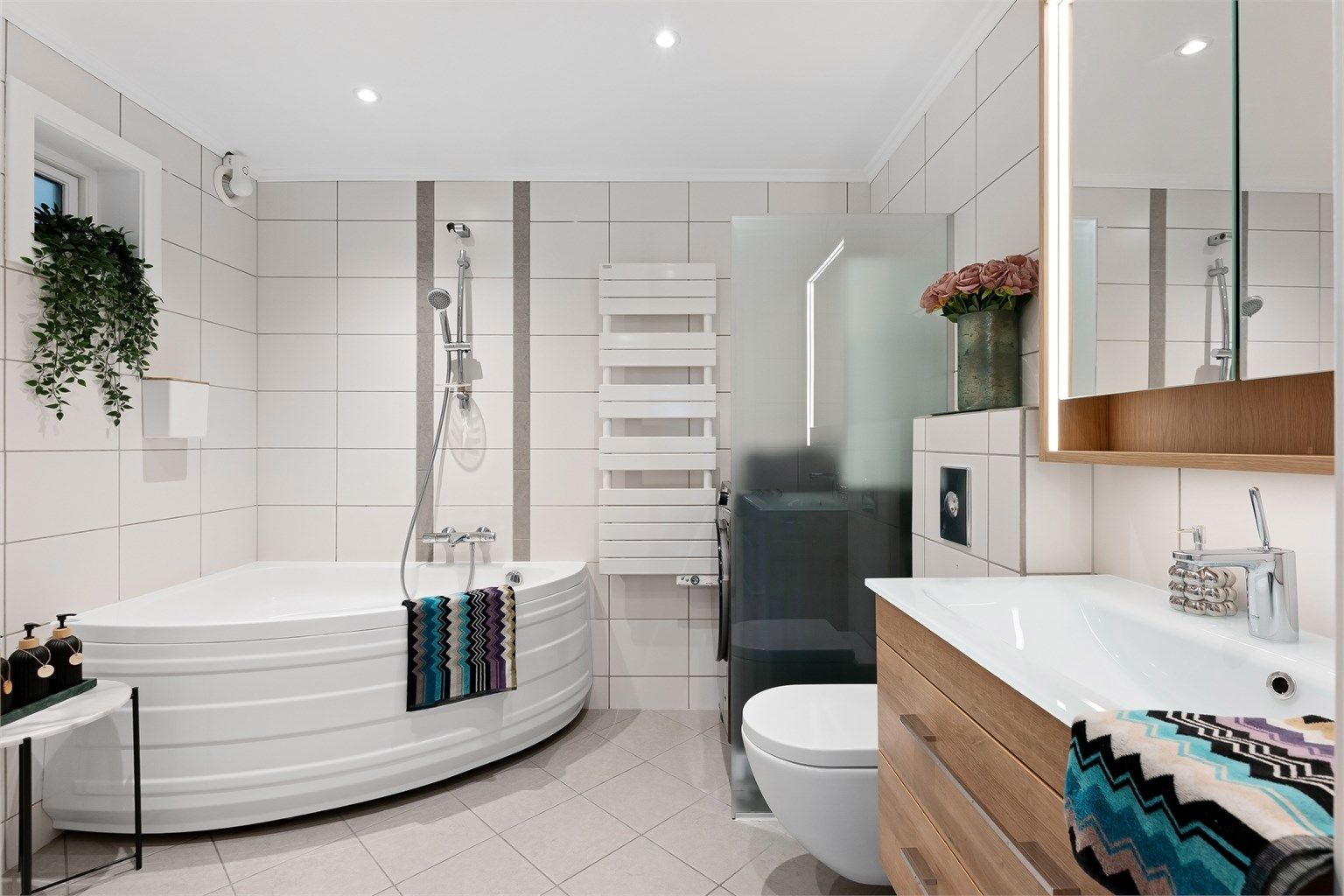 Pent baderom med fliser på gulv med gulvvarme, fliser på vegger og malt himling