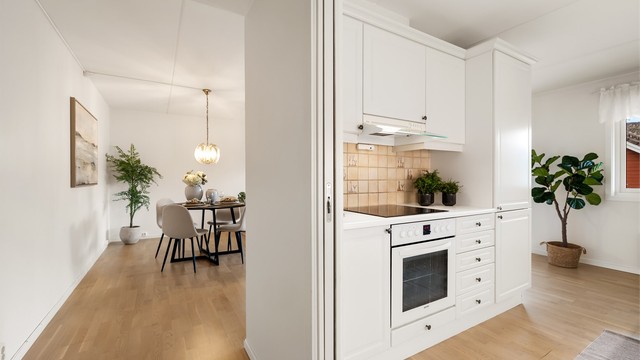 Flislagt felt på vegg over laminerte benkeplater. Lysarmaturer under overskap.