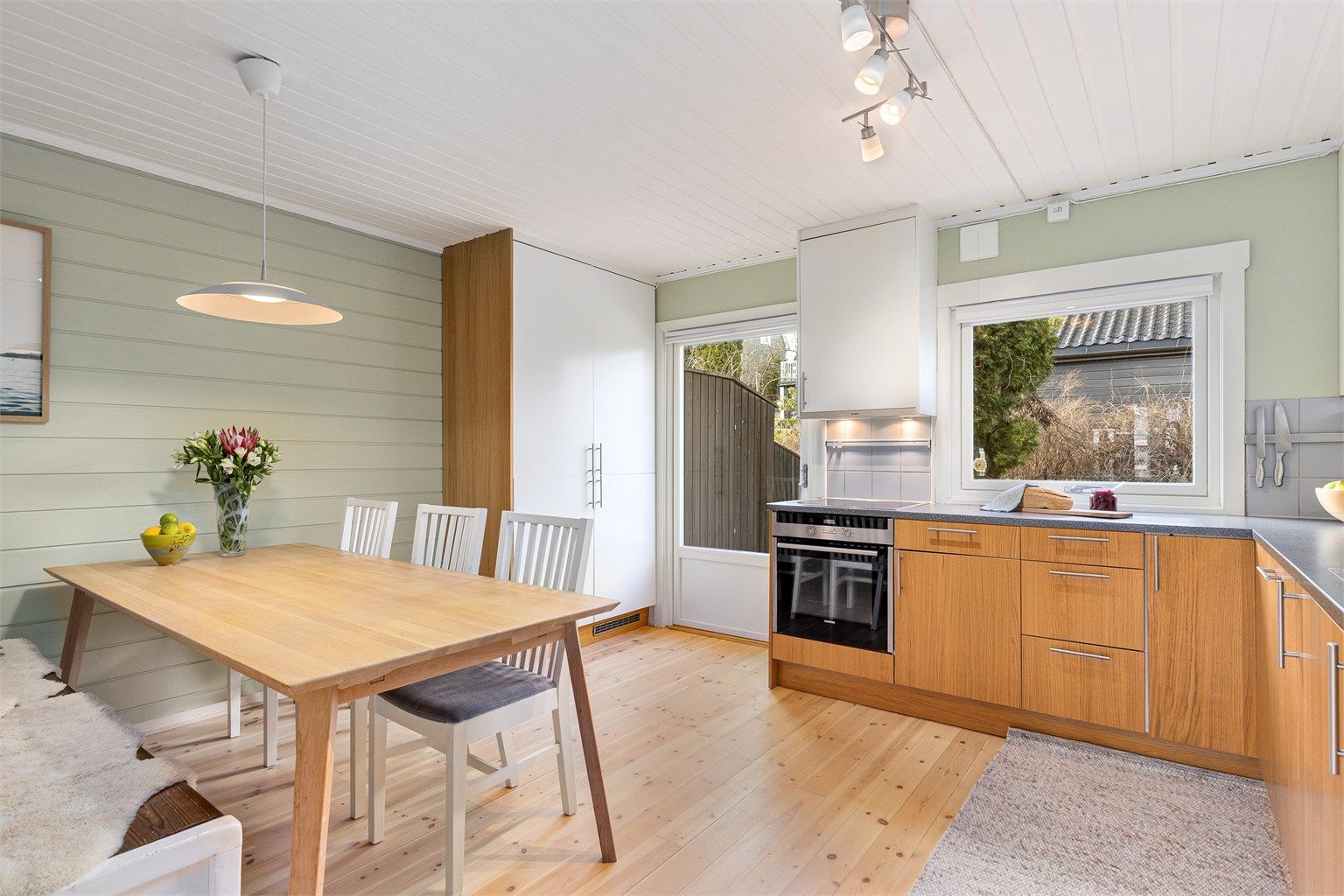 Rommet får et fint naturlig lys gjennom vindusflatene, og det er direkte adkomst til en herlig uteplass fra kjøkkenet