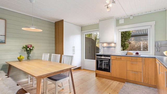 Rommet får et fint naturlig lys gjennom vindusflatene, og det er direkte adkomst til en herlig uteplass fra kjøkkenet