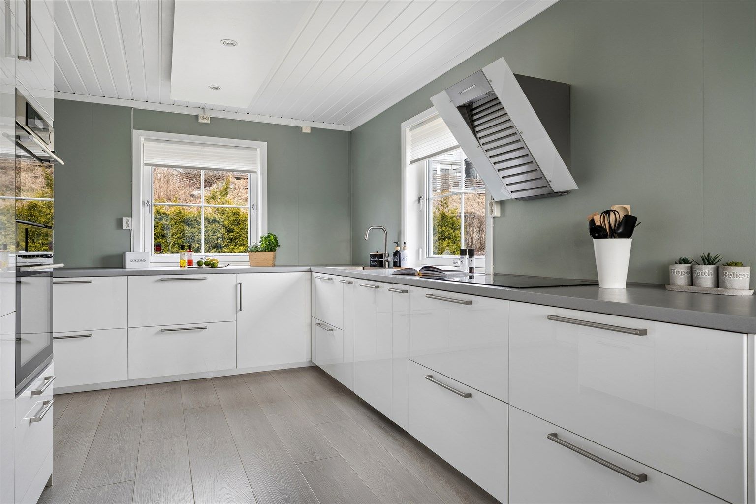 Kjøkkenet har innredning med glatte fronter og laminert benkeplate, samt integrerte hvitevarer.