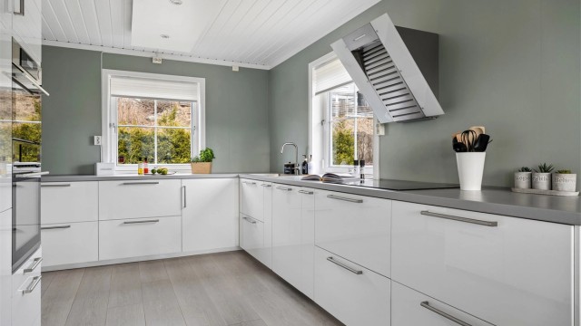 Kjøkkenet har innredning med glatte fronter og laminert benkeplate, samt integrerte hvitevarer.