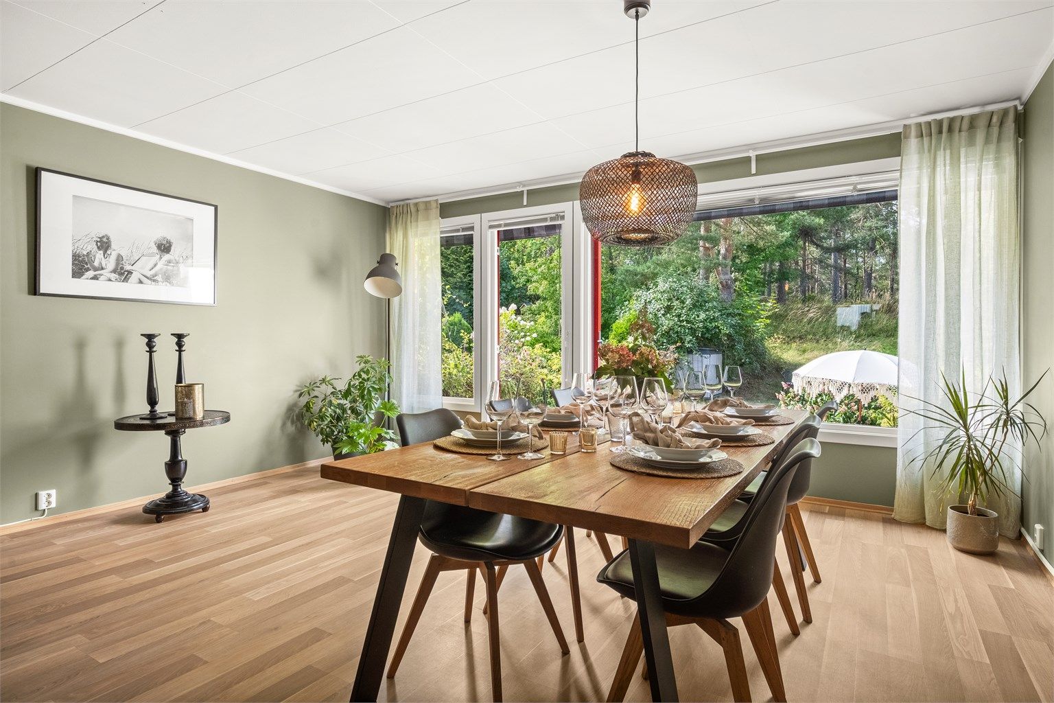 Spisestuen har store vinduer med utsikt mot hagen og skogen.