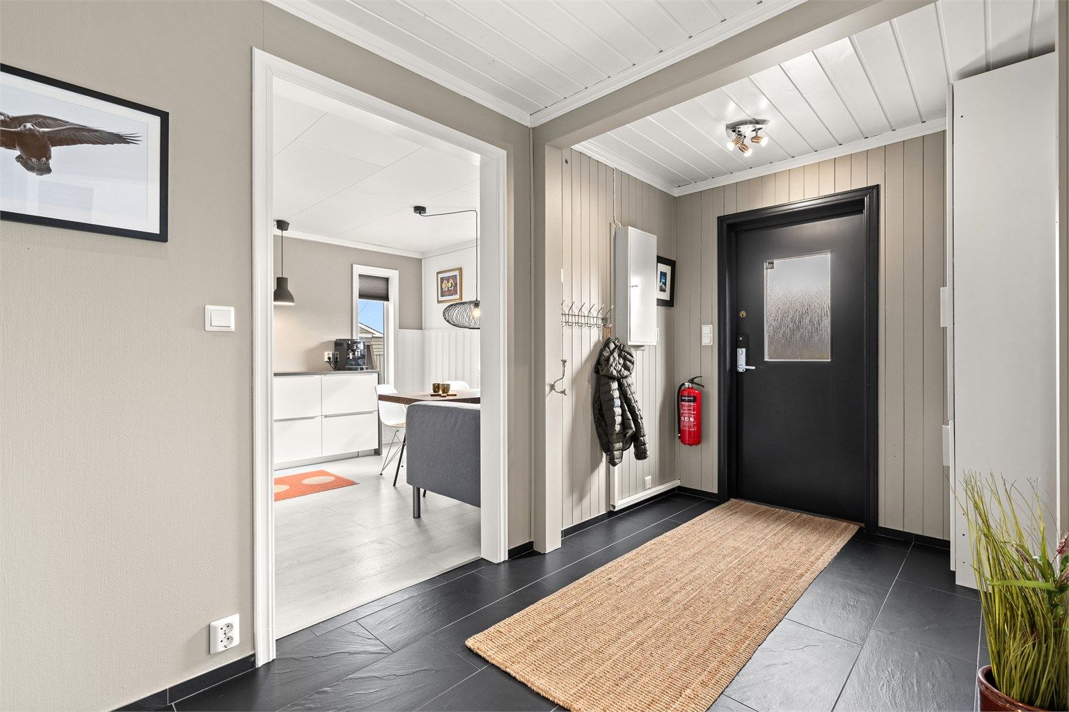 Velkommen inn, boligen har en romslig gang med praktisk garderobeskap ved inngangsdøren