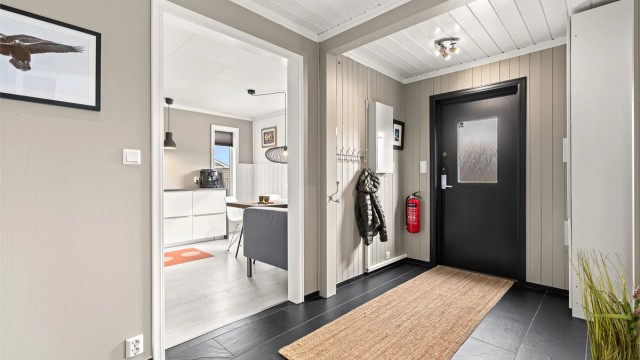 Velkommen inn, boligen har en romslig gang med praktisk garderobeskap ved inngangsdøren