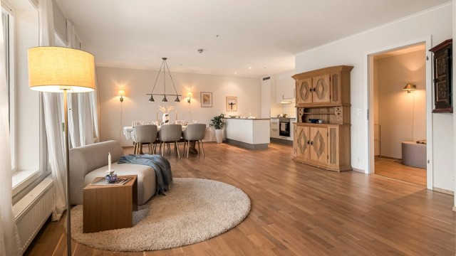 Åpen stue/kjøkkenløsning hvor kjøkkenet er noe tilbaketrukket og således fint skjermet