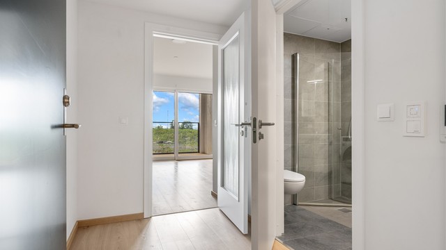 Entréen har adkomst til badet og leder videre inn til stuen. Vannbåren gulvvarme gir en lun velkomst.