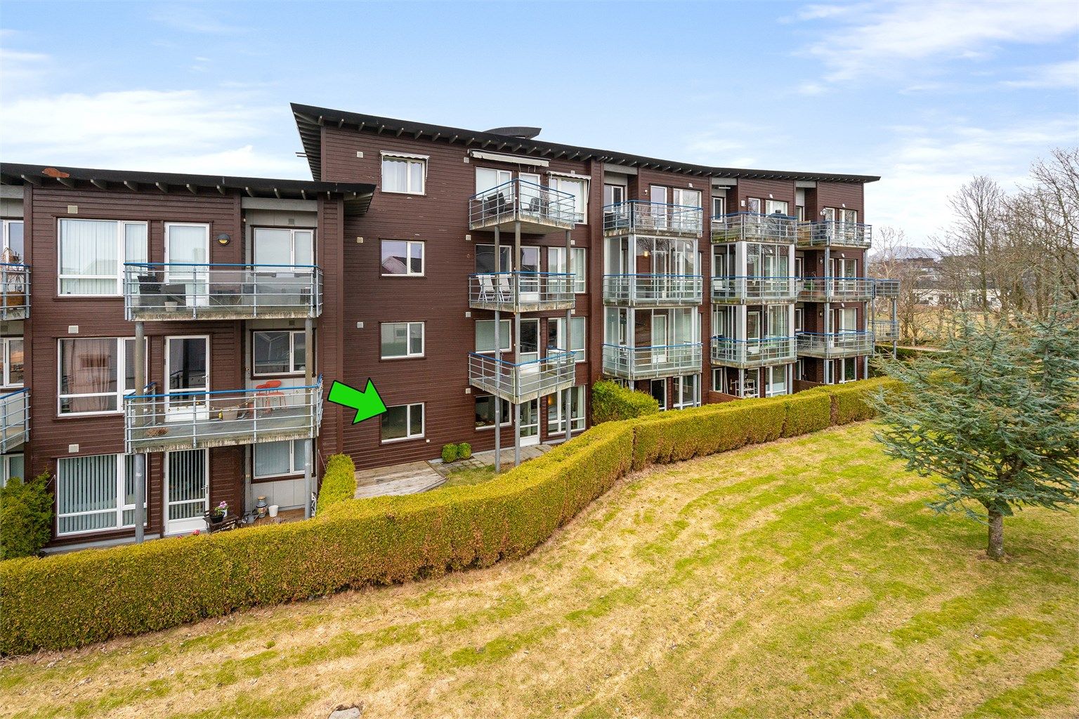 Bygget har en fasade kledd med liggende dobbelfalset kledning og malte betongvegger.