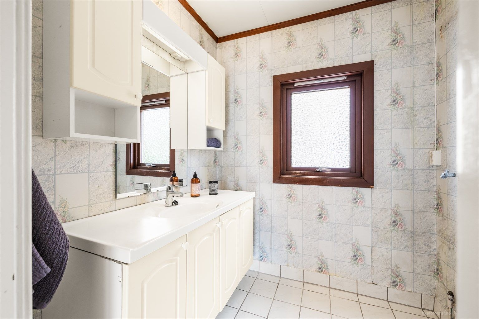 Badet i første etasje har flislagt gulv og servantinnredning med oppbevaring.