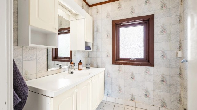 Badet i første etasje har flislagt gulv og servantinnredning med oppbevaring.