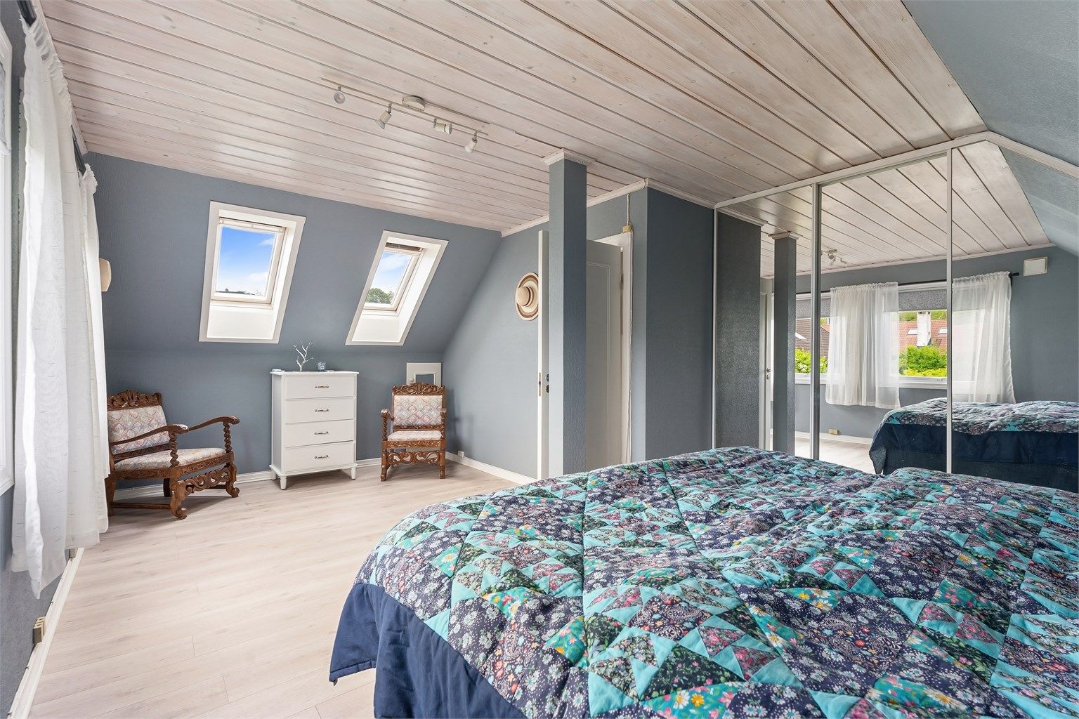 En stor skyvedørsgarderobe med speilfronter gir rikelig med oppbevaringsplass på hovedsoverommet.