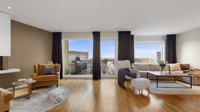 Lys og innbydende stue med store vindusflater som gir rikelig med naturlig sollys.