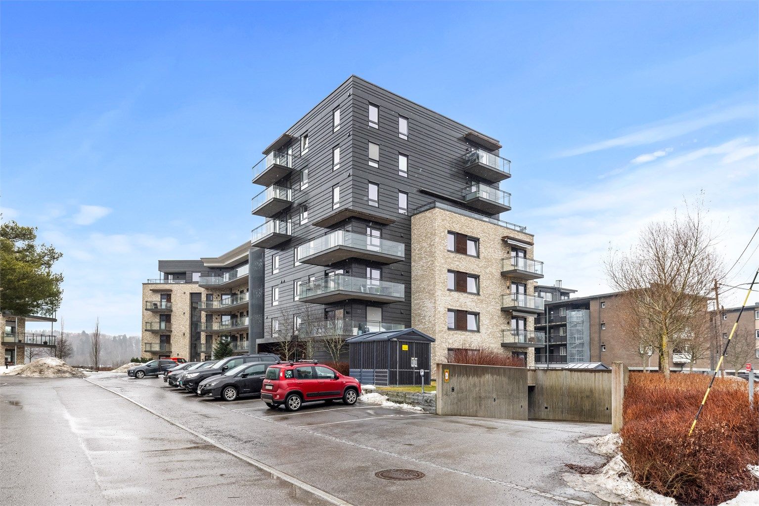 Moderne leilighetsbygg fra 2018 med fasader i teglstein, trekledning og plater.