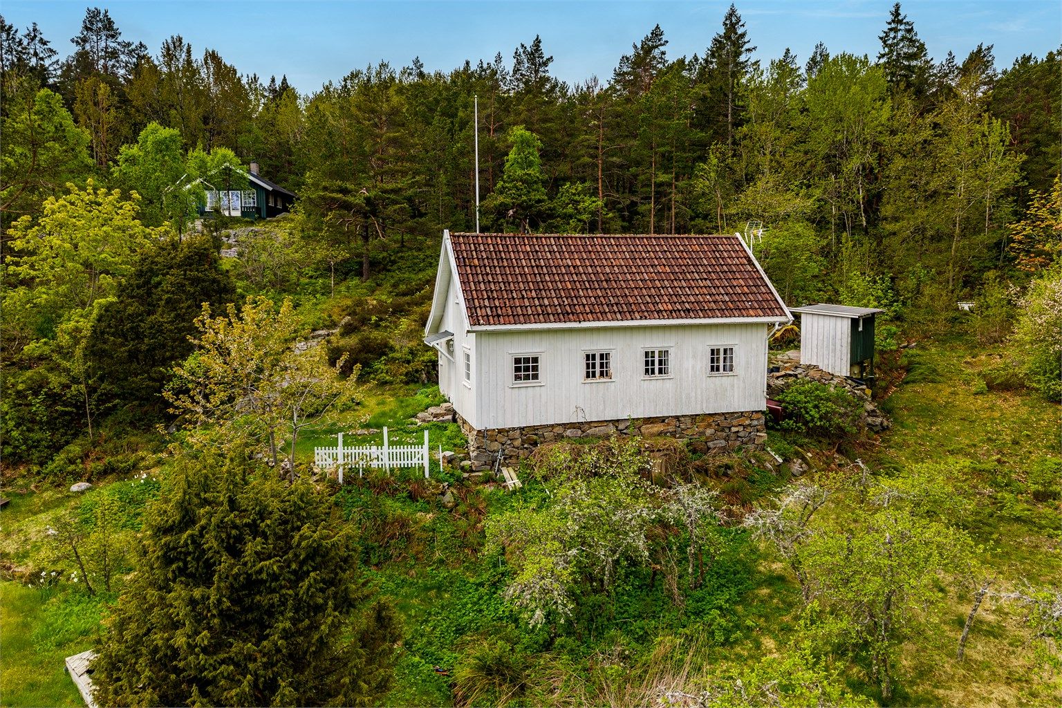 I en frodig skråing rett opp for Arøybukta, skrår en gammel nyttehage ned mot en åpen slette som tidligere var dyrket mark. Herfra fører en sti ned til bukta og sjøen hvor  det er sjøbod og egen brygge.