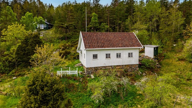I en frodig skråing rett opp for Arøybukta, skrår en gammel nyttehage ned mot en åpen slette som tidligere var dyrket mark. Herfra fører en sti ned til bukta og sjøen hvor det er sjøbod og egen brygge.