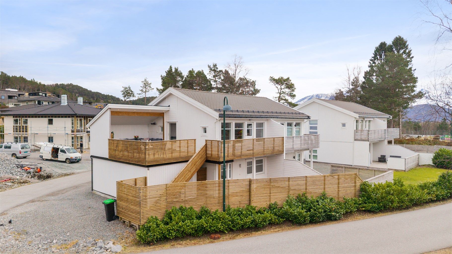 En utvendig trapp i tre forbinder den øvre verandaen med terrassen på bakkeplan.