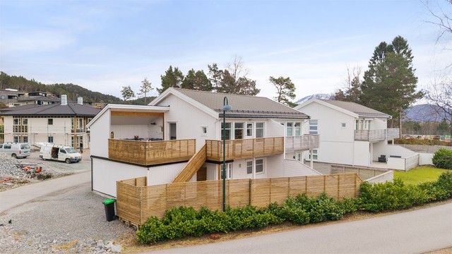 En utvendig trapp i tre forbinder den øvre verandaen med terrassen på bakkeplan.