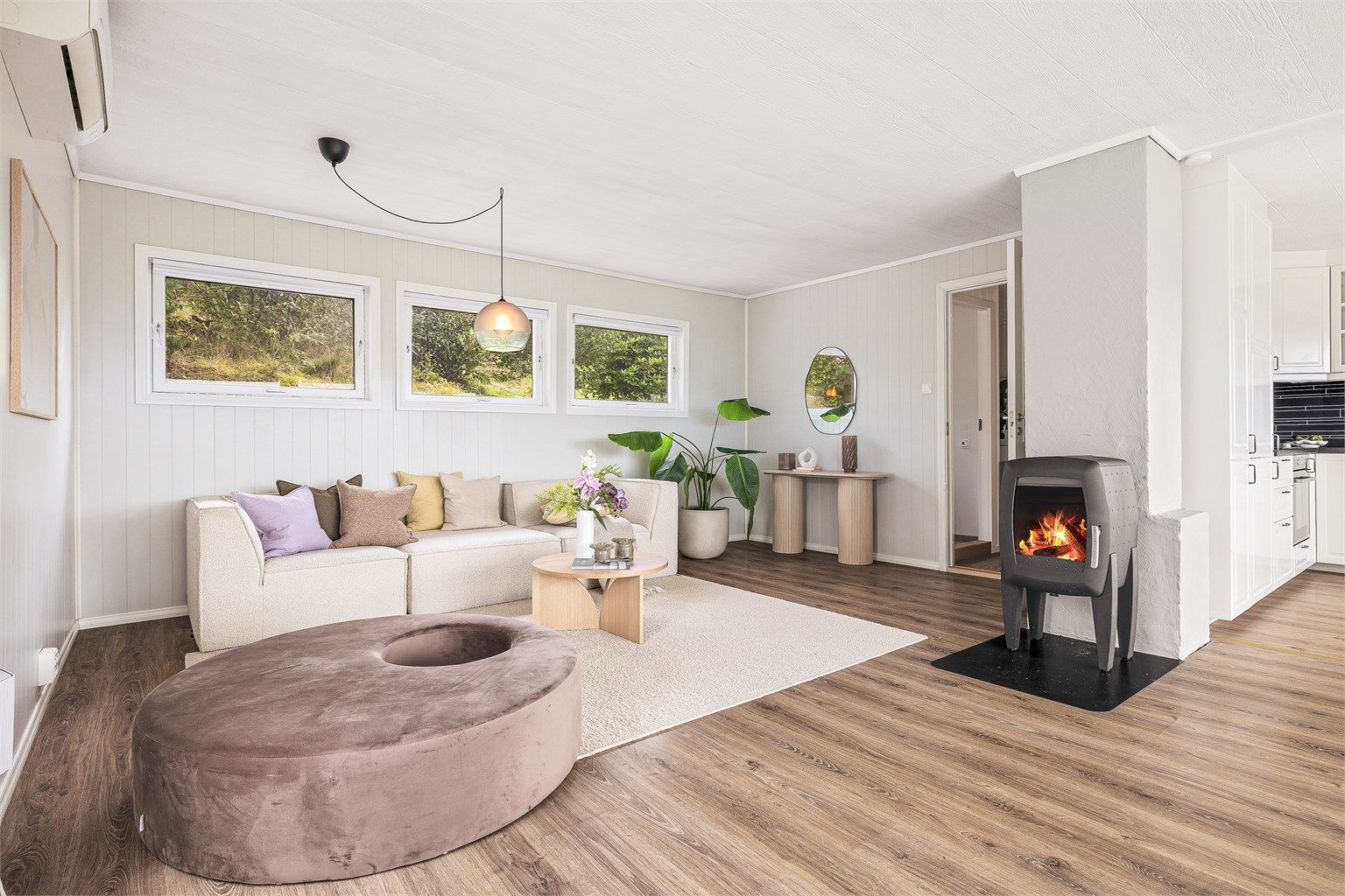 Åpen og lys stue med peisovn. 