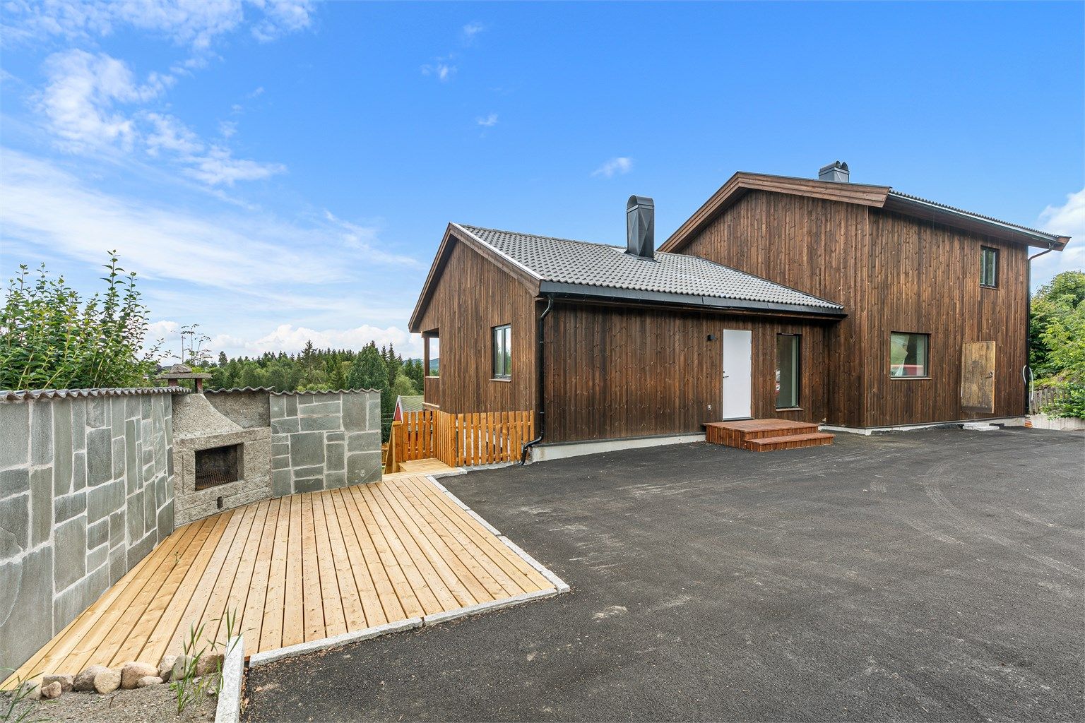 Inngangssiden har fin gårdsplass og en super terrasseplatting med utepeis