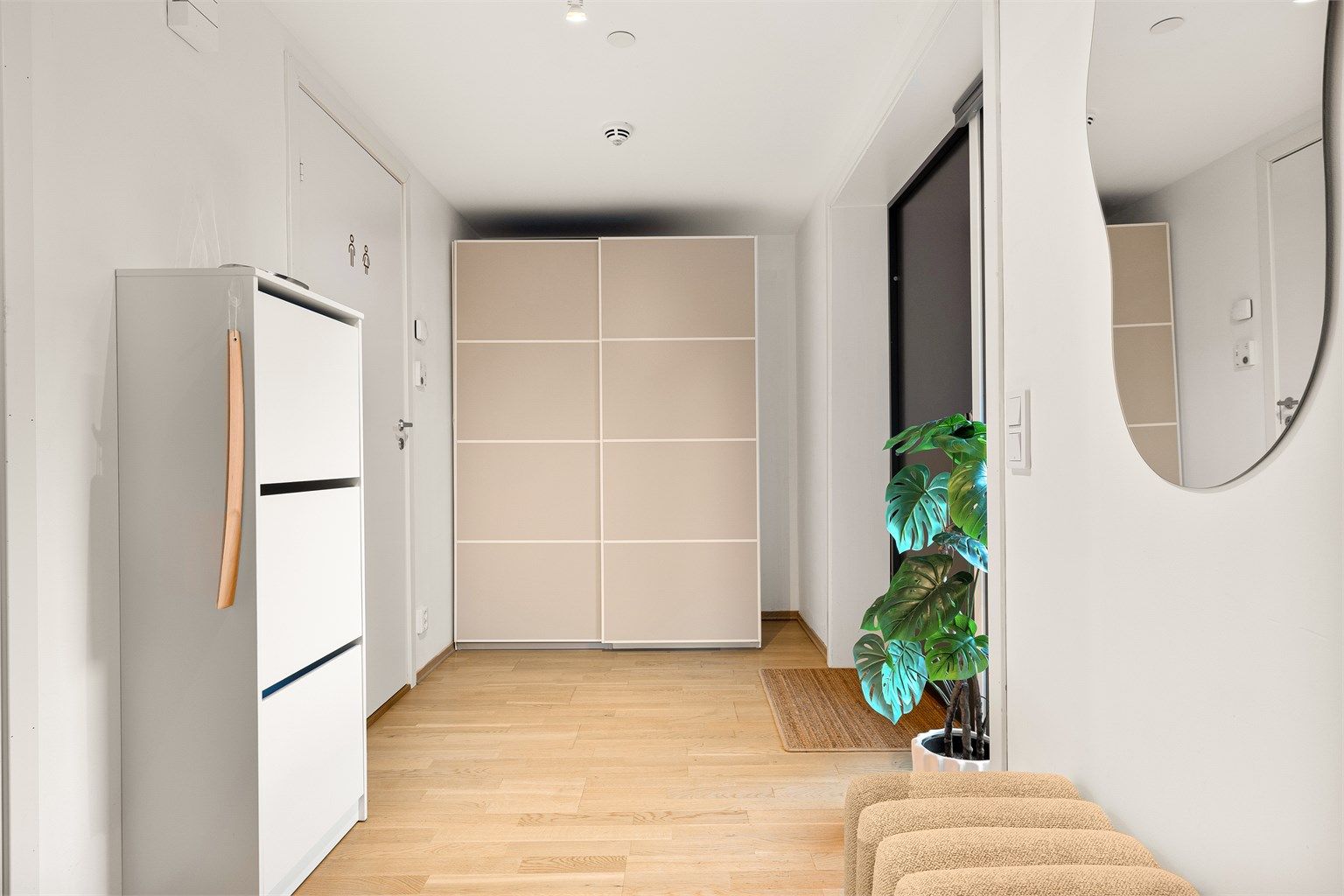Entré med vannbåren gulvvarme og romslig skyvedørsgarderobe.