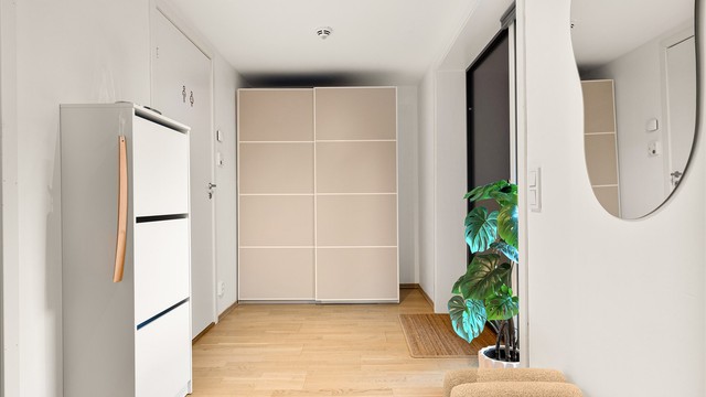 Entré med vannbåren gulvvarme og romslig skyvedørsgarderobe.