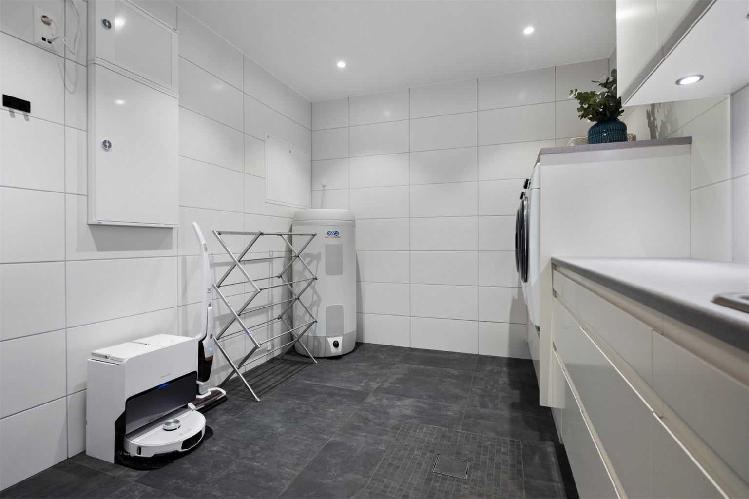 Romslig vaskerom med stor innredning med god plass til vaskemaskin og tørketrommel 