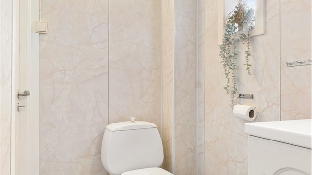 Badet har gulvbelegg, baderomsplater på vegger og takplater i himling.