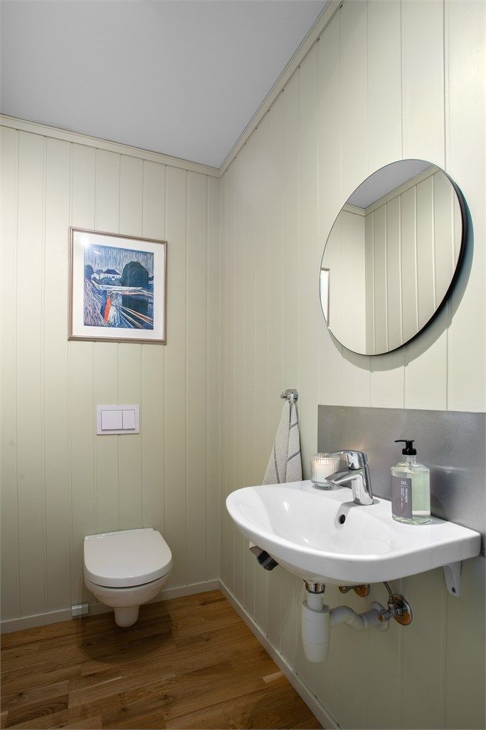 Toalettrom med 3-stavsparkett på gulv. Innredet med vegghengt servant og toalett