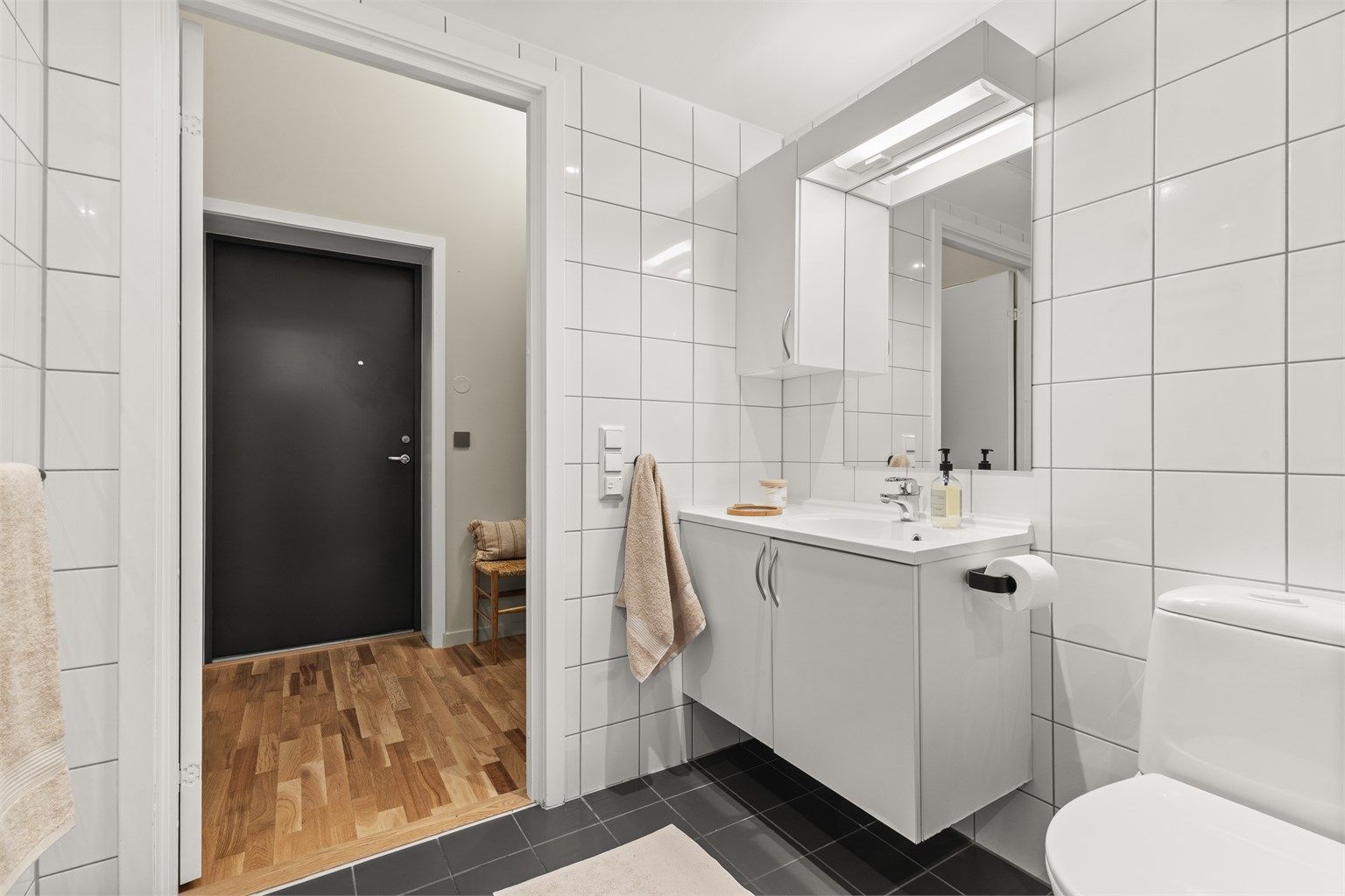 Badet har vegghengt toalett, god oppbevaringsplass og funksjonelle løsninger.