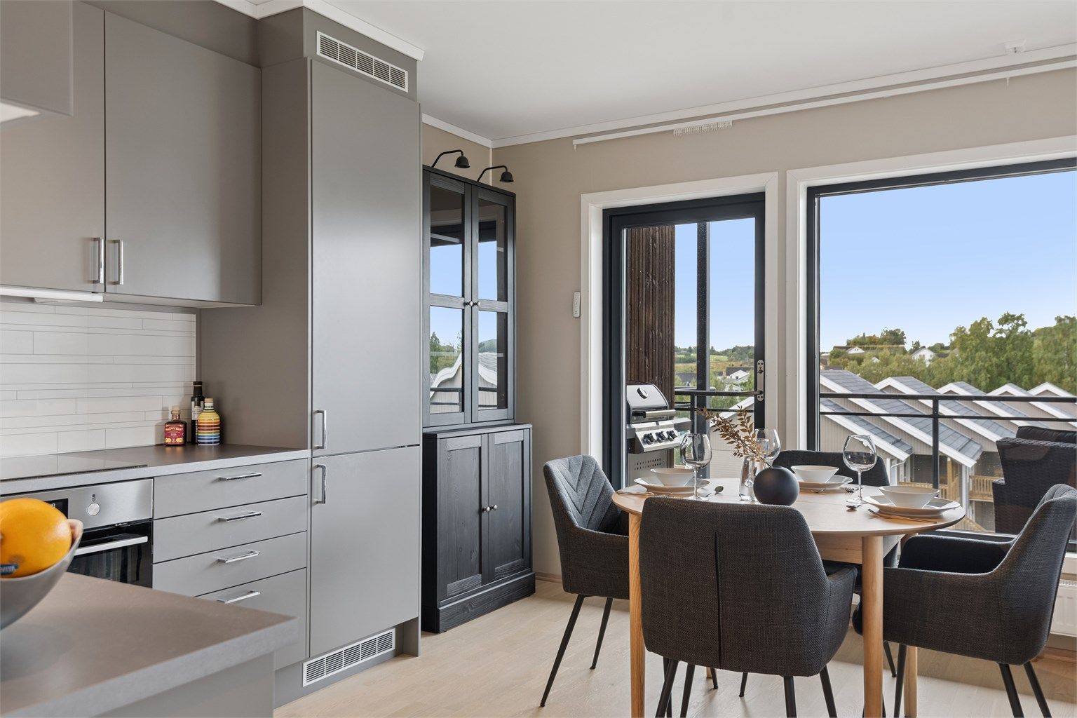 Kjøkkenet ligger i åpen løsning mot stuen og har moderne innredning med glatte fronter og laminert benkeplate.