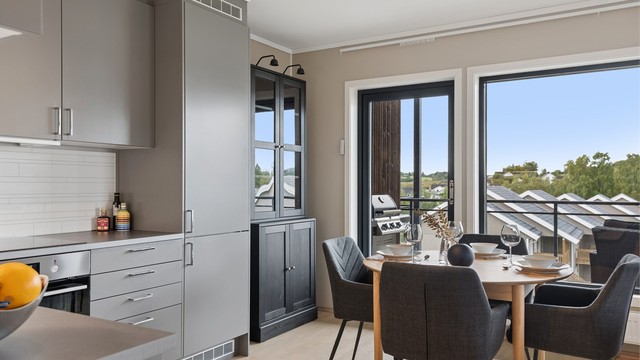 Kjøkkenet ligger i åpen løsning mot stuen og har moderne innredning med glatte fronter og laminert benkeplate.