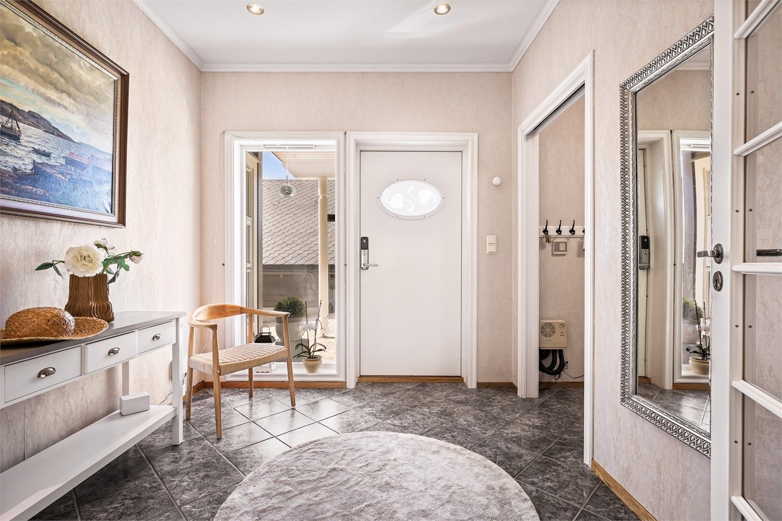 Velkommen inn. Romslig entré med fliser på gulvet og tilhørende garderoberom. Vannboren varme og 2,7 meter takhøyde er gjennomgående i etasjen.