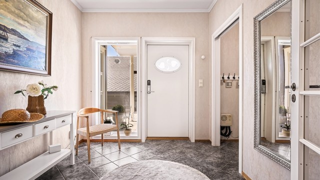 Velkommen inn. Romslig entré med fliser på gulvet og tilhørende garderoberom. Vannboren varme og 2,7 meter takhøyde er gjennomgående i etasjen.