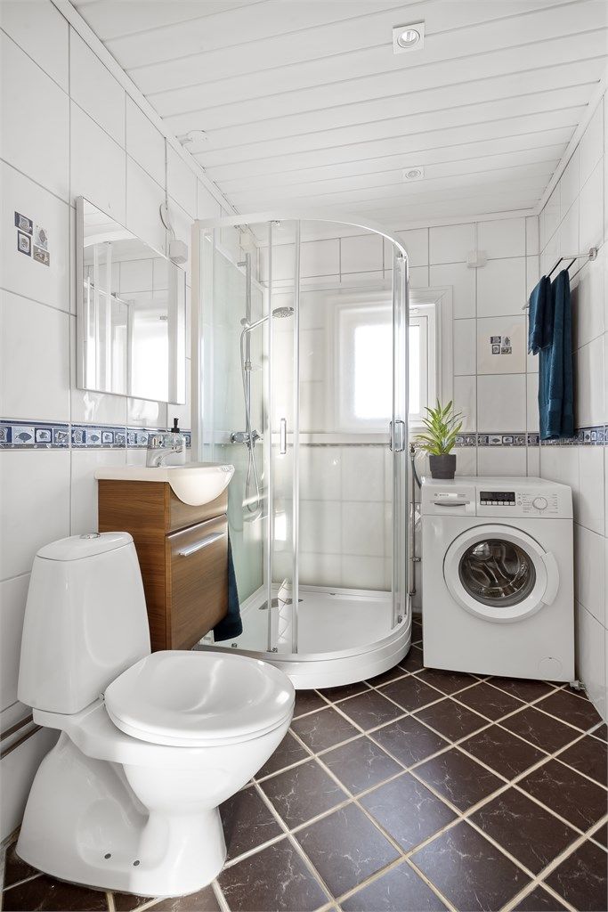 Badet er innredet med servant, speil, høyskap og toalett.