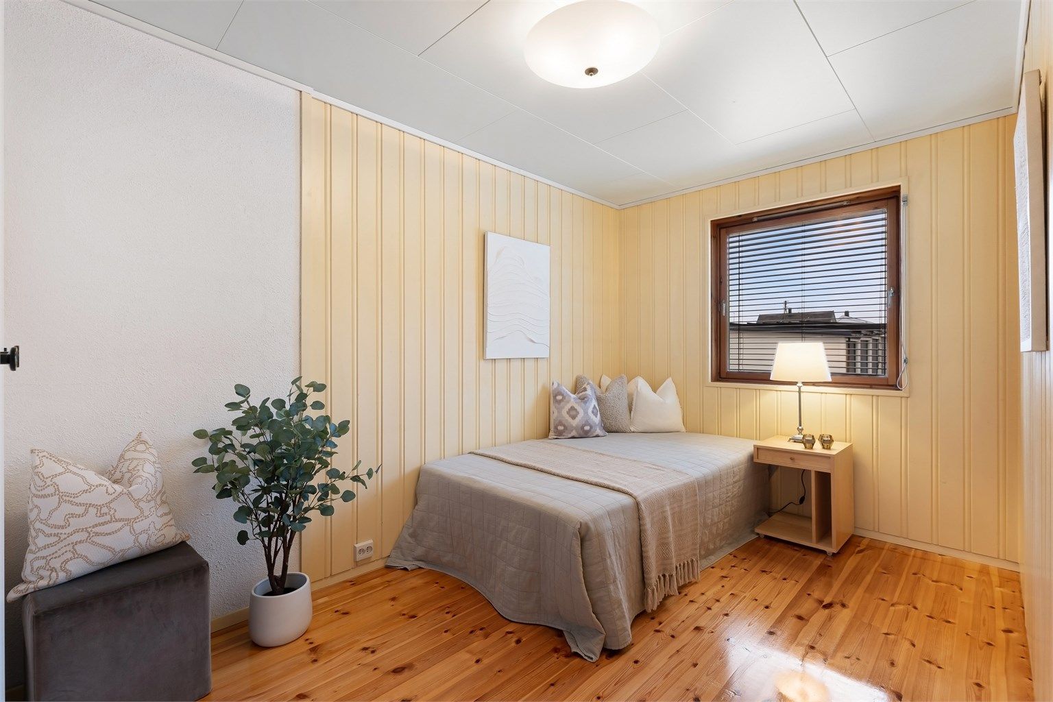 Boligens tredje soverom ligger også i denne etasjen, med heltre på gulvet og malte panelvegger.